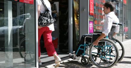 A wheelchair user entering a building